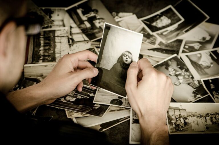 Homme qui regarde plusieurs photos souvenirs