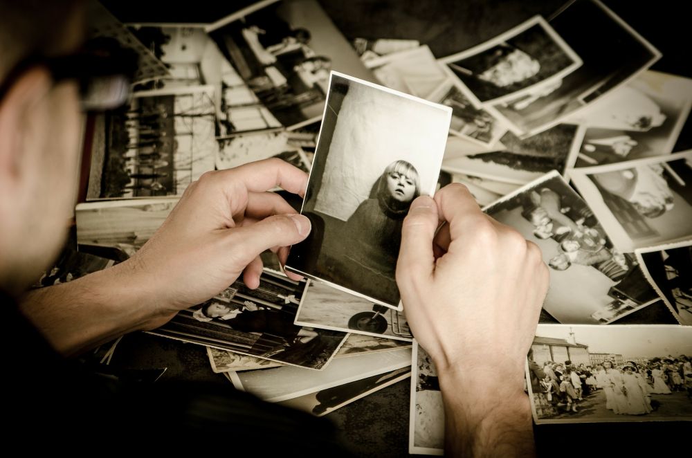 Homme qui regarde plusieurs photos souvenirs